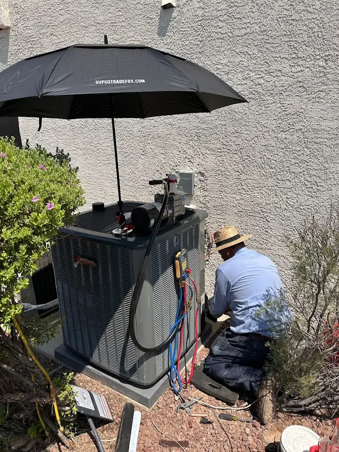 HVAC technician performing outdoor AC maintenance in North Strabane